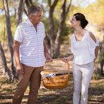 Smiling couple holding a wicker basket during safari vacation