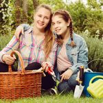 10 Best Outdoor Gift Baskets for Mom positive young mother and dauther with gardening tools in outdoors